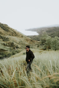 Rear view of woman standing on field
