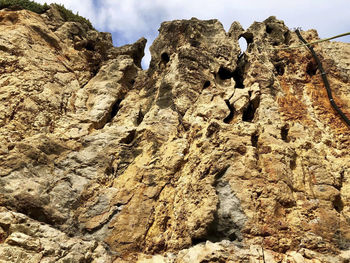 Low angle view of rocky mountains against sky