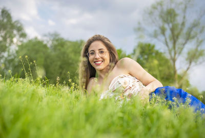 Portrait of young woman standing on field