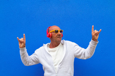 Portrait of man wearing sunglasses against blue sky