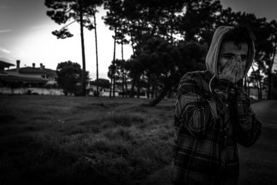 Smiling man covering face on road