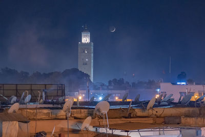 Satellite dish on building terrace against sky at night