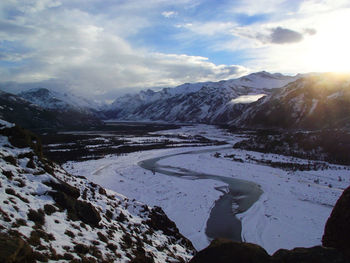 Scenic view of river and snowcapped mountains against sky