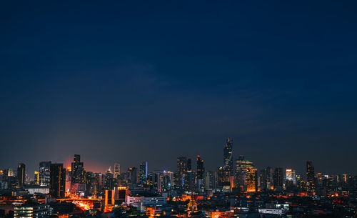 Illuminated buildings in city against sky at night