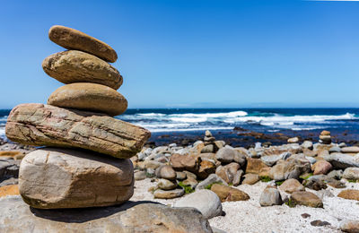 Stack of pebbles on beach against sky