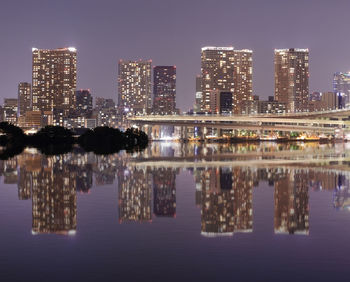 Reflection of buildings in lake at night