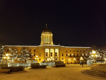 Illuminated building against sky at night