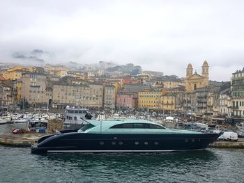 Boats in city against sky