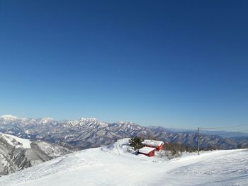 Scenic view of snowcapped mountains against clear blue sky