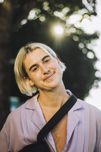 Portrait of smiling non-binary person with blond hair