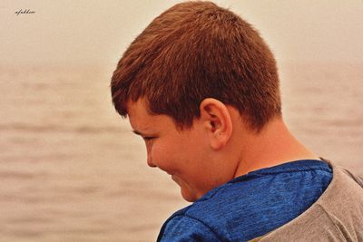 Close-up portrait of boy looking at beach