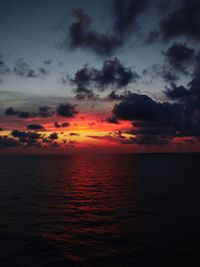 Scenic view of sea against dramatic sky during sunset