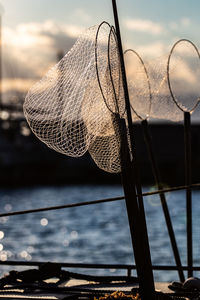 Close-up of fishing net in lake against sky