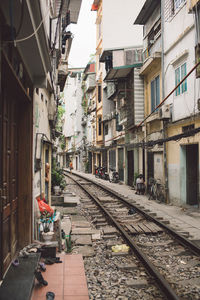 Railroad tracks amidst buildings in city