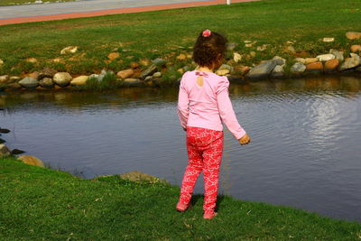 Rear view of woman standing on pink water