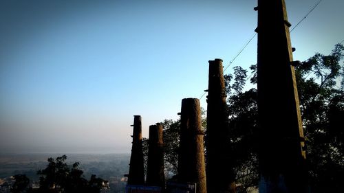 Trees against clear sky during sunset