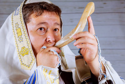 Close-up of man eating food while wearing headscarf