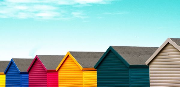Low angle view of beach huts against sky