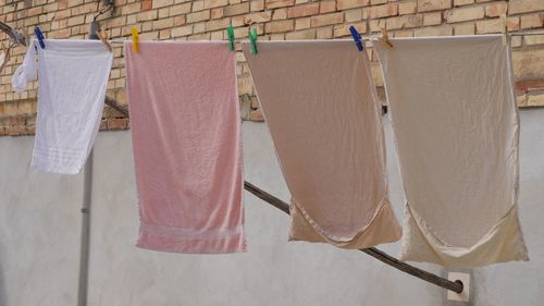 Close-up of clothes drying on clothesline against white wall
