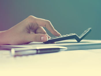 Midsection of person using mobile phone on table