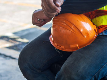 Low angle view of man working on pumpkin during halloween