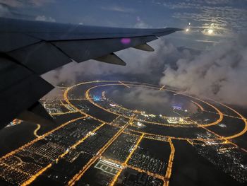 Aerial view of illuminated cityscape against sky at night