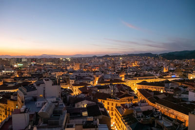 High angle view of illuminated buildings in city against sky during sunset