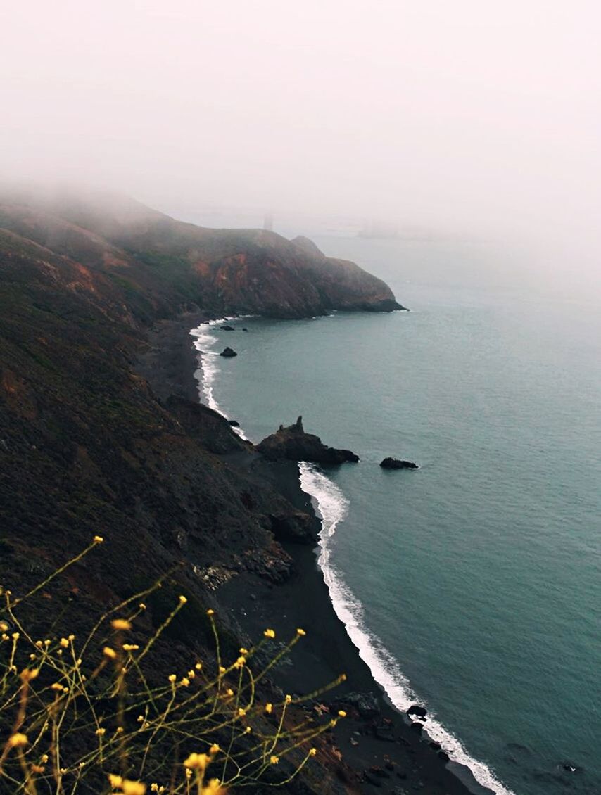 water, sea, beauty in nature, tranquility, scenics - nature, tranquil scene, land, nature, sky, beach, mountain, no people, non-urban scene, fog, day, cliff, outdoors, idyllic, rocky coastline