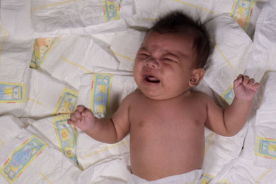 High angle view of baby lying on bed