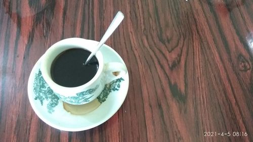 High angle view of coffee cup on wooden table