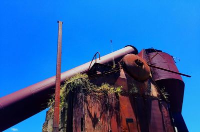 Low angle view of abandoned building against clear blue sky