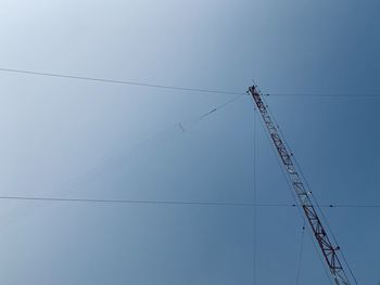 Low angle view of power lines against clear blue sky