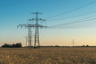 Electricity pylon on field against sky