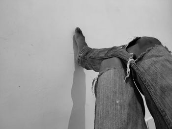 Low section of woman standing against wall