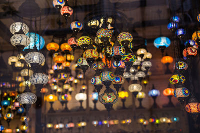 Illuminated lanterns hanging in store for sale