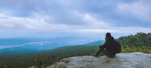 Side view of dog on mountain against sky