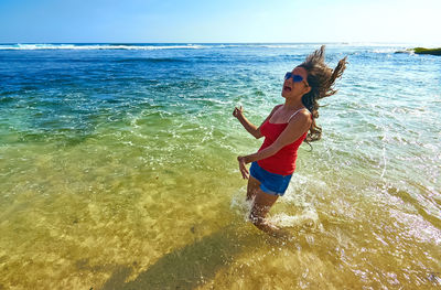 Happy woman dancing in sea