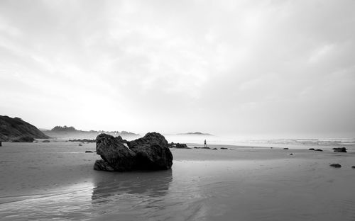 Rocks on beach against sky