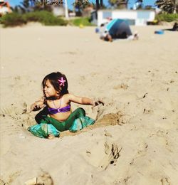 Girl wearing sunglasses on sand at beach