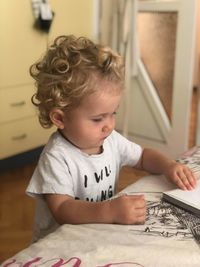 Baby boy with book at table