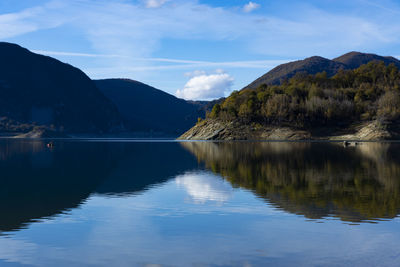 Scenic view of lake by mountains against sky