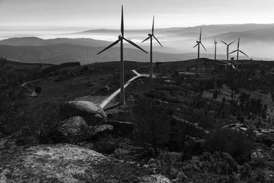 Windmills on landscape against sky