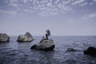 Scenic view of rocks in sea against sky