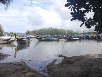 Boats moored on shore against sky