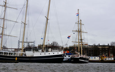 Sailboats moored on sea against sky