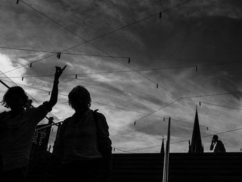 Low angle view of silhouette people against sky