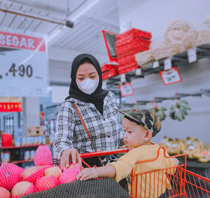 Portrait of smiling young woman standing in shopping mall