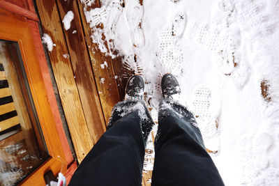 Pants full of snow and footprints on the wood 