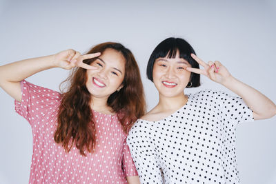 Portrait of lesbian couple against gray background