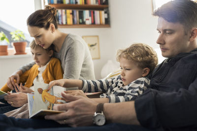 Parents reading picture books to children at home